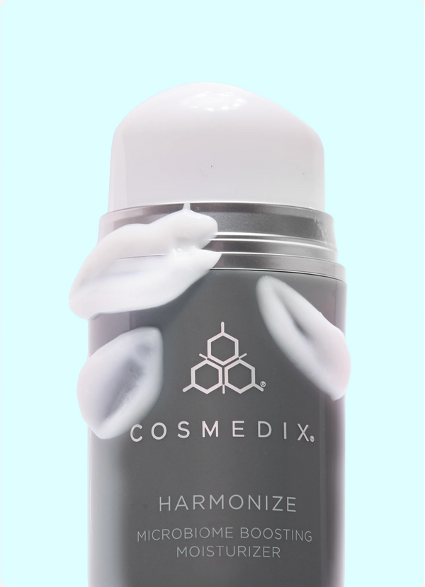 Cosmedix moisturizer bottle with cream on a light blue background