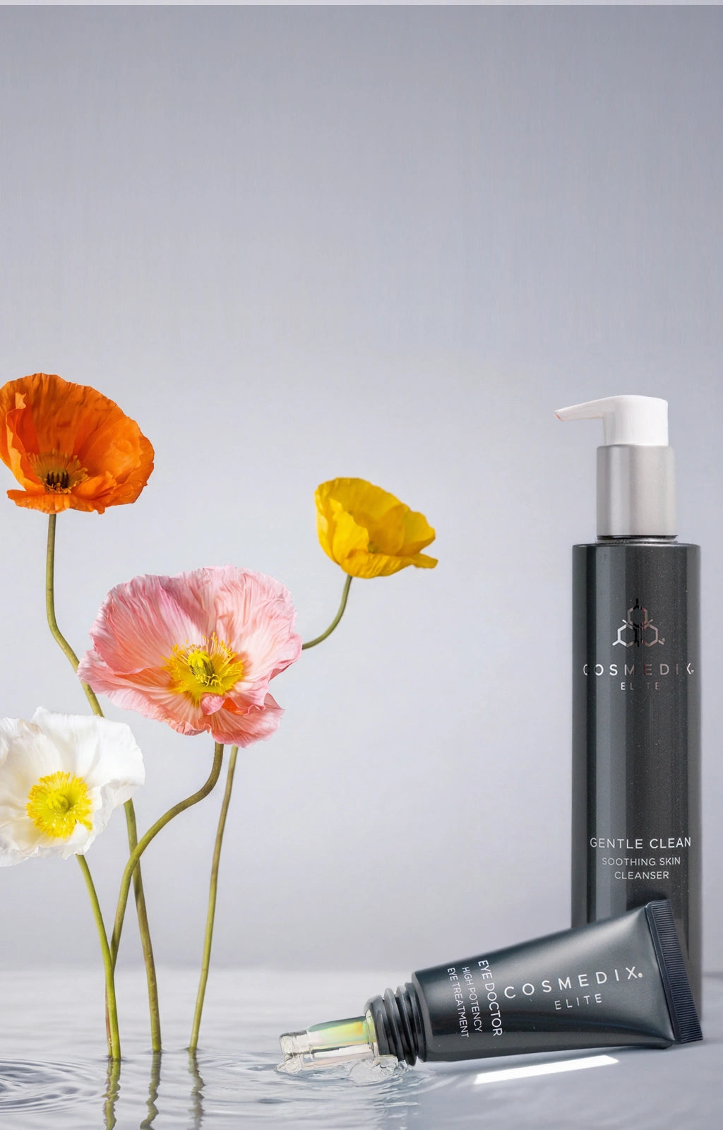 Free shipping with any elite product purchase. Gentle Clean Cleanser in dark gray bottle with Eye Doctor Eye Serum and Plants against light gray background.